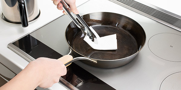 Use a paper towel or similar to wipe it down, rubbing it in. (*Be careful as it will be hot.)