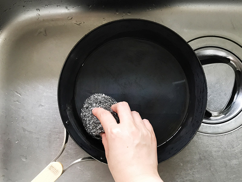 鉄フライパンの錆びをスチールたわしでこする
