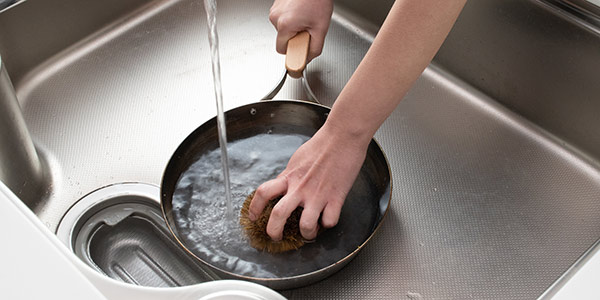 鉄フライパンが温かいうちに、たわしやササラを使いお湯で洗います