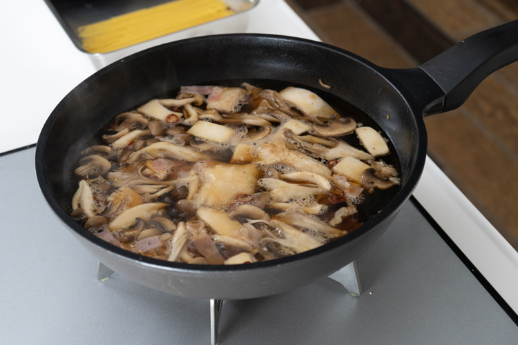 きのこがしんなりしてきたら水、和風だし、醤油、塩、こしょうを加え沸騰するまで中火で加熱する。