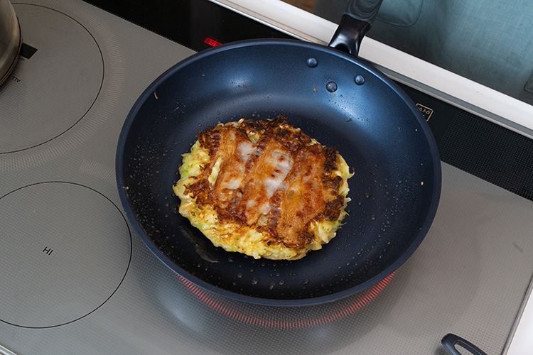 豚バラ肉をのせひっくり返し、蓋をして4分程度加熱する