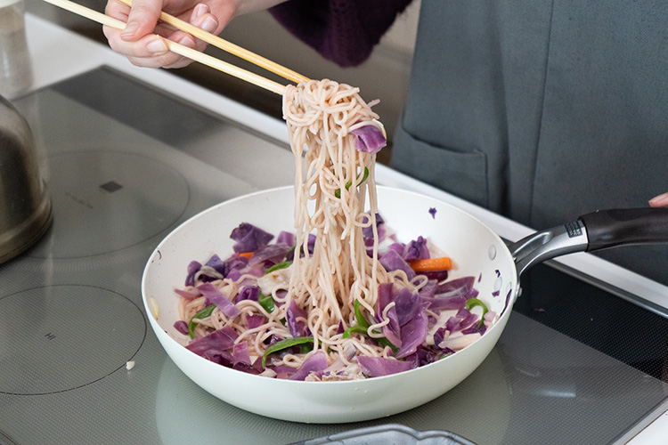 麺全体がピンク色になるまで混ぜ合わせる。