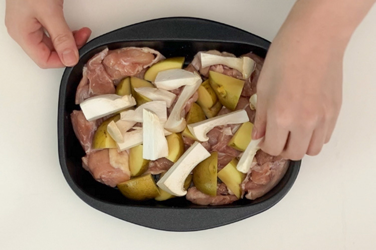 鶏もも肉に塩、こしょうをし、皮目を下にして入れる。じゃがいも、エリンギを加える。