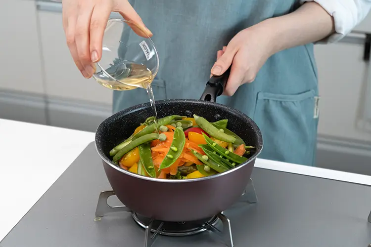 パプリカ、にんじん、アスパラガス、スナップえんどうを入れ、白ワインを加える