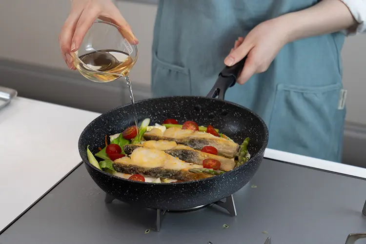 野菜の上に手順3の材料を乗せ、アスパラガス、ミニトマト、白ワインを加える