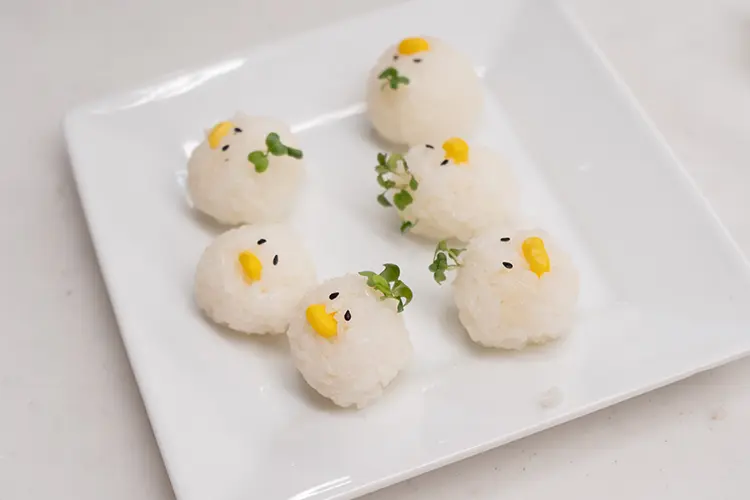 水気を切ったコーン(缶詰)、かいわれ大根、いりごま(黒)で顔を飾る