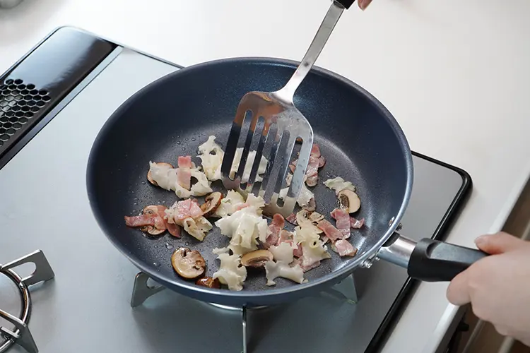 フライパンにオリーブオイルを引いて中火で加熱し、マッシュルーム、ベーコンを加える。軽く炒めたら花びら茸を加え、塩、こしょうをしさらに炒める