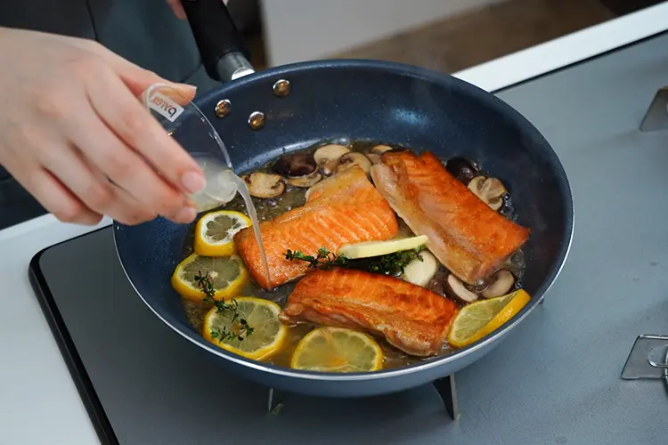 生鮭の両面に焼き色がついたら白ワインを加える