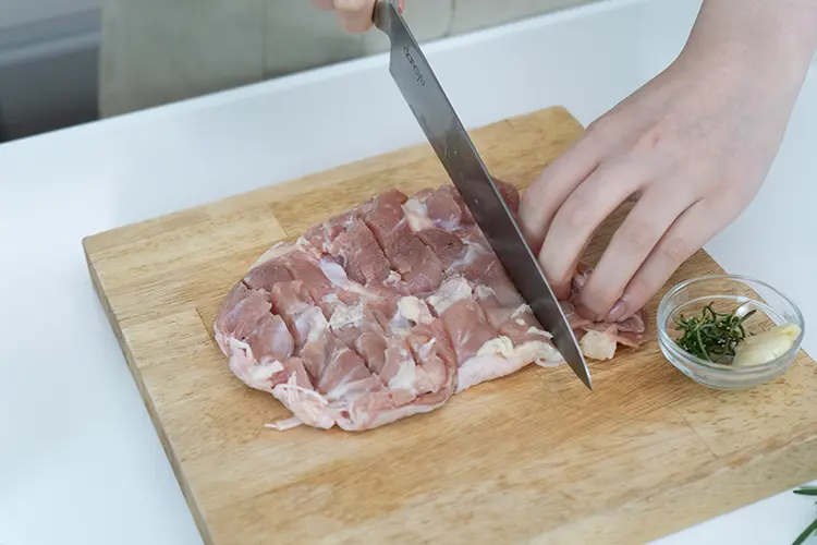 鶏もも肉は皮目を下にして置き、厚みのある部分は包丁で開く