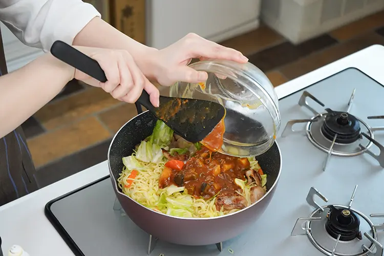 麺がほぐれたらカレー、ウスターソースを加え全体を混ぜ合わせる。