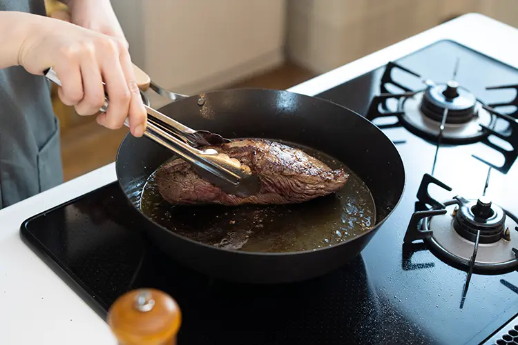 牛もも肉を入れ、塩、ブラックペッパーを振る