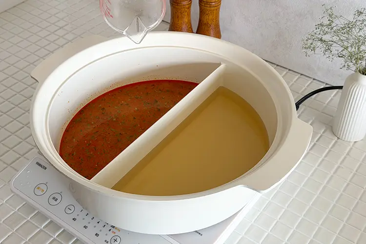 鍋の左側に【つけ汁】の【A】を入れよく混ぜ合わせる。鍋の右側に【うどん】の【B】を入れ蓋をし、中火で加熱する。