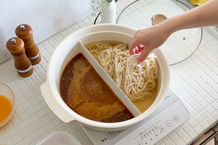 沸騰したら、【つけ汁】にトマト、【うどん】に冷凍うどんを加え、再度蓋をし加熱する。