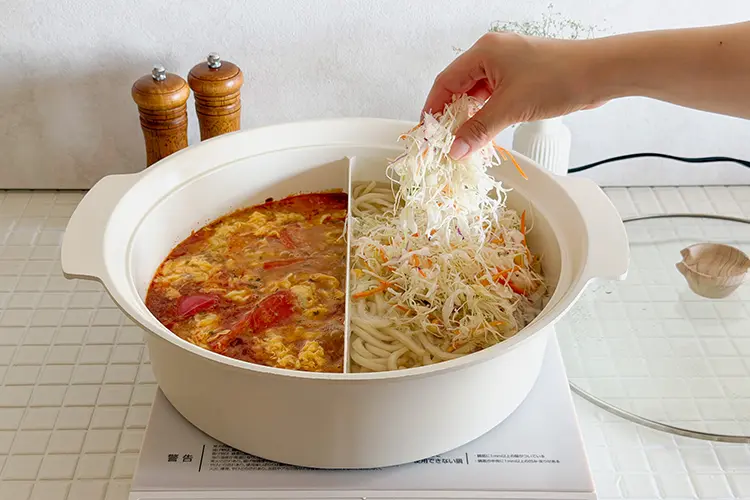【うどん】にカット野菜を加え、食材に火が通るまで加熱したら出来上がり。