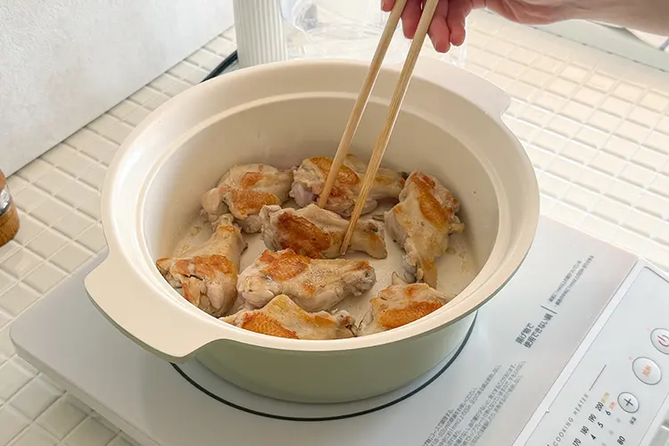 鶏手羽元を皮目から入れ、中火で加熱する