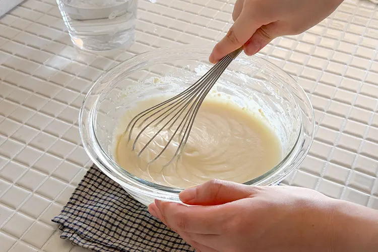ボウルなどの器に絹豆腐を入れ、クリーム状になるまで混ぜる。