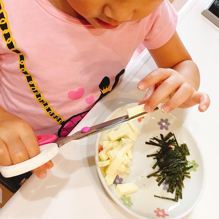 チーズをハサミで切る子ども