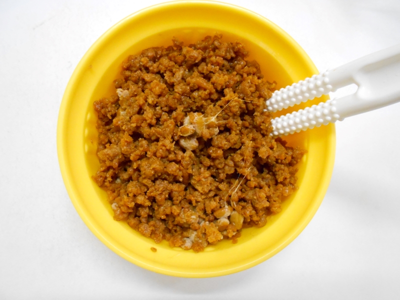 納豆とタレ、鶏そぼろを器に入れ、納豆スティックでよく混ぜる