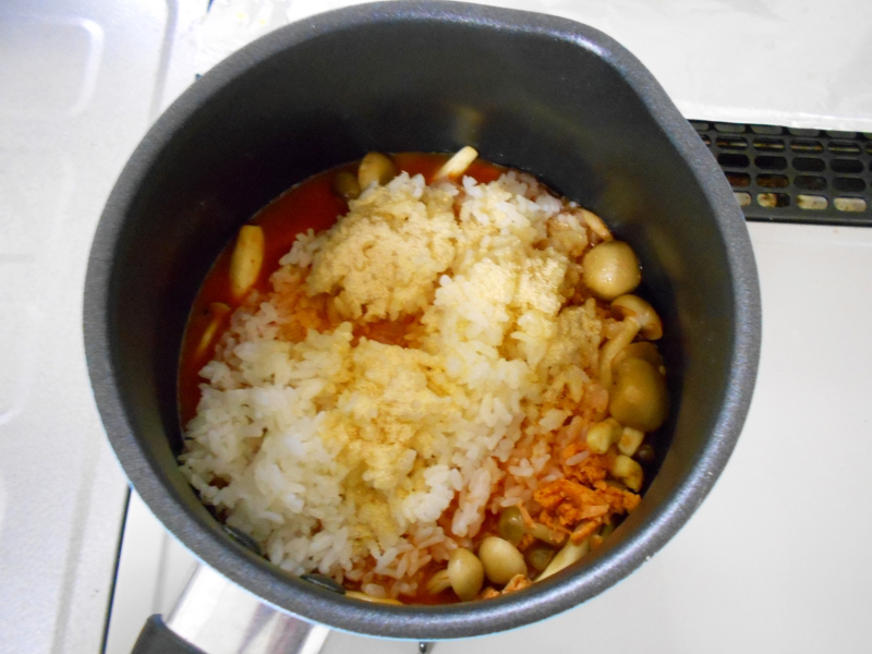 野菜ジュース、水、ごはん、鮭フレーク、だしの素が鍋に入っている画像
