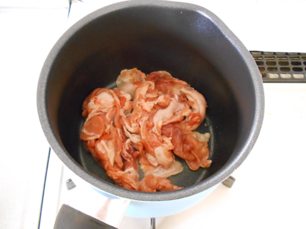 肉を炒めている