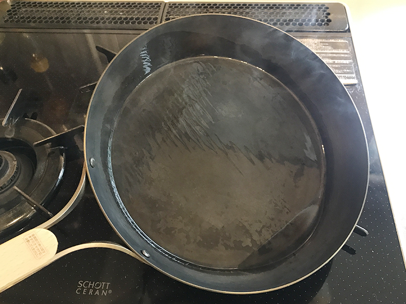油をなじませている鉄フライパン